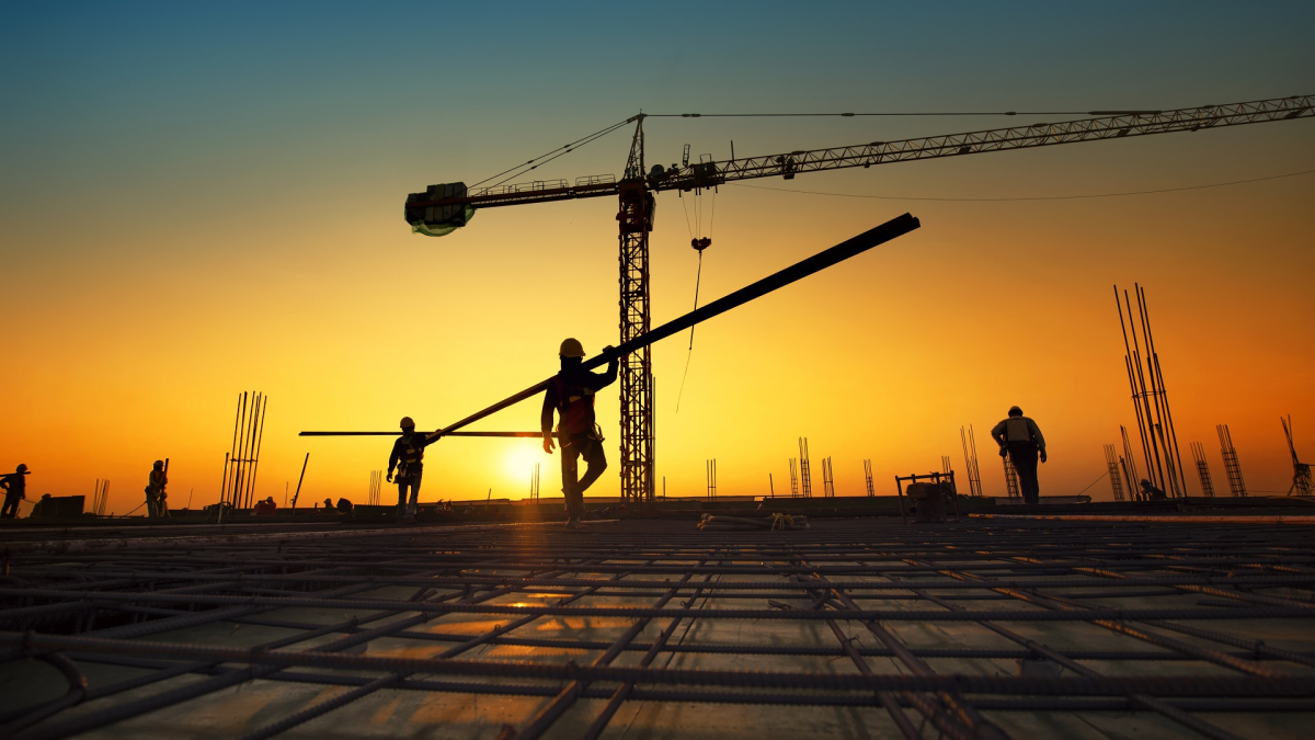 Silhouette construction workers fabricating steel reinforcement