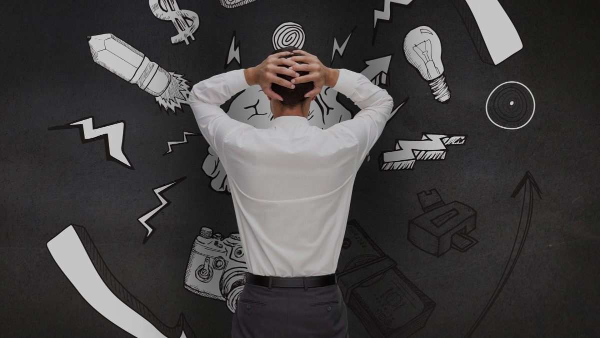 Rear view of a confused man looking at graphics on black wall