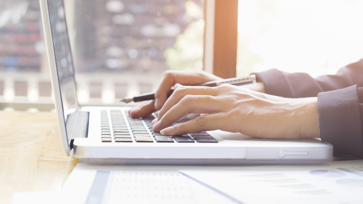 Business woman's hands typing on laptop keyboard