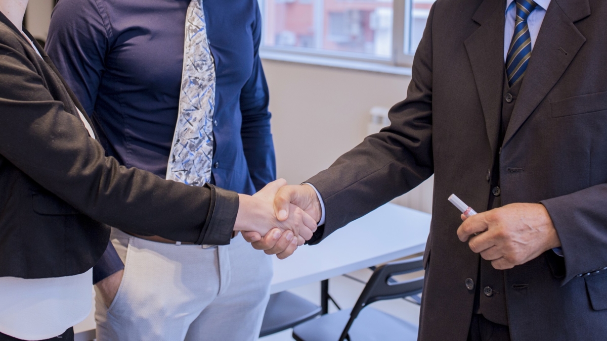 happy-business-people-shaking-hands-after-finishing-up-meeting