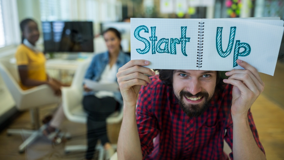 Male graphic designer holding spiral notepad with a text